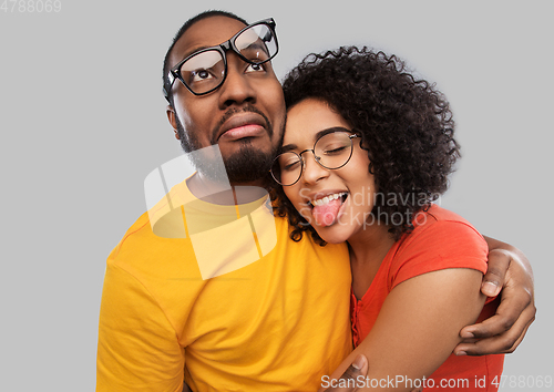 Image of happy african american couple in glasses hugging