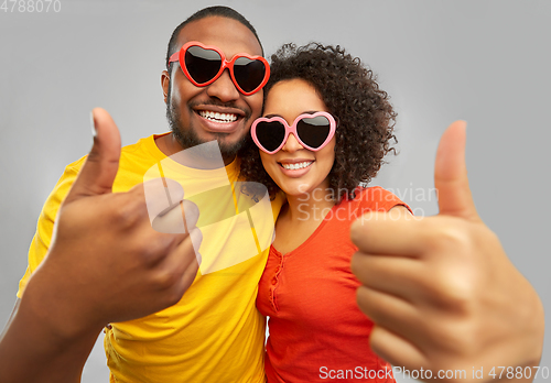 Image of happy african couple in heart shaped sunglasses