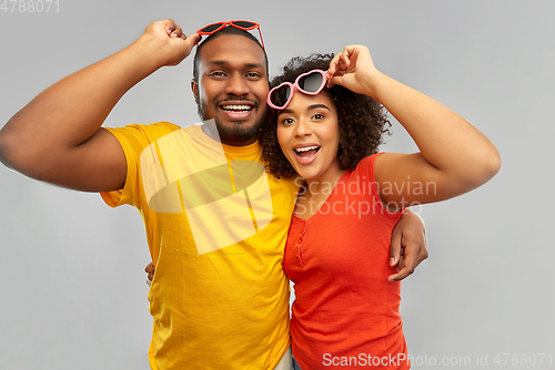 Image of happy african couple in heart shaped sunglasses