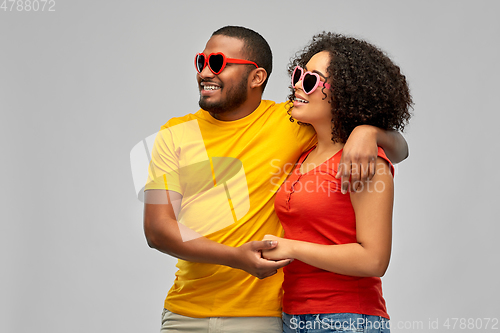 Image of happy african couple in heart shaped sunglasses