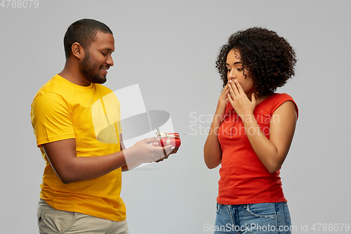 Image of happy african american couple with red gift box