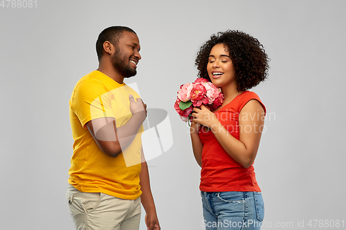 Image of happy african american couple with flowers