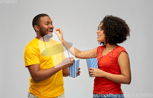 Image of happy african american couple eating popcorn