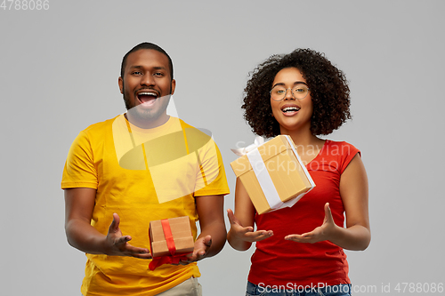 Image of happy african american couple throwing gift boxes