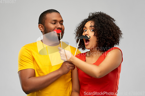 Image of happy african american couple with party props