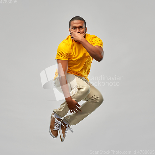 Image of young african american man jumping in air