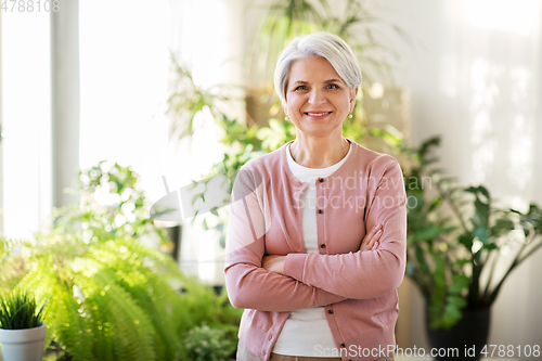 Image of happy senior woman with cup of tea at home