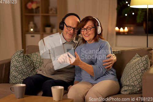 Image of senior couple with smartphone and headphones