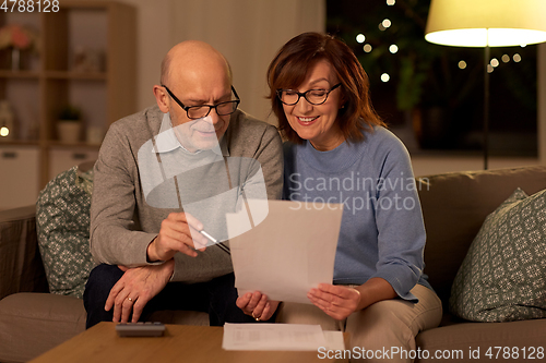 Image of senior couple with papers and calculator at home