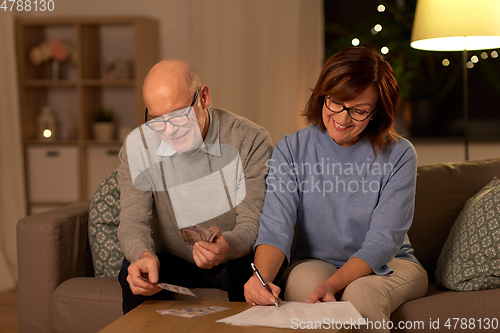 Image of senior couple with bills counting money at home