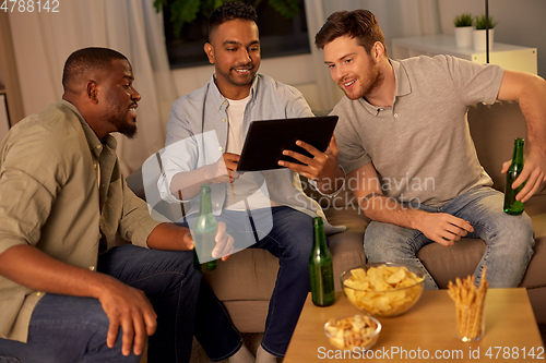 Image of male friends with tablet pc drinking beer at home