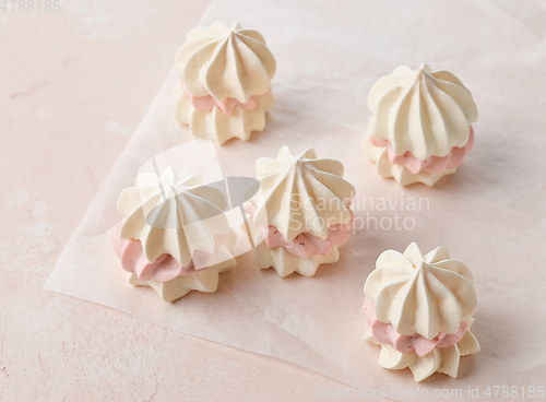 Image of meringue cakes on pink background