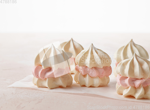Image of meringue cakes on pink background