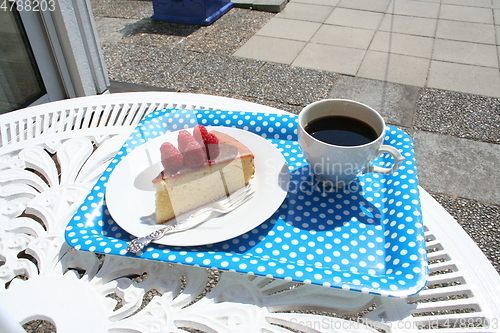 Image of Piece of cake together with a cup of coffee