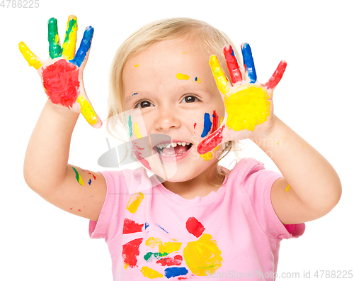 Image of Portrait of a cute little girl playing with paints