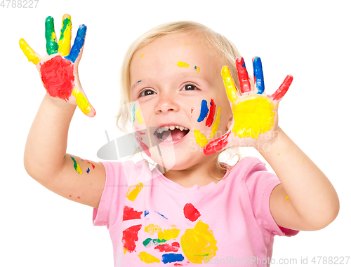 Image of Portrait of a cute little girl playing with paints