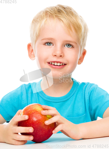 Image of Portrait of a cute little boy with red apple