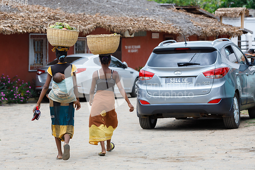 Image of Malagasy women traditionally carry a basket of fruit on their he