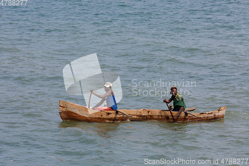 Image of Malagasy man on sea in traditional handmade dugout wooden boat