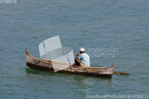 Image of Malagasy man on sea in traditional handmade dugout wooden boat