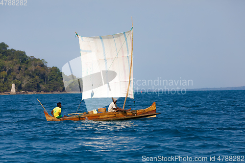 Image of Malagasy man on sea in traditional handmade dugout wooden sailin