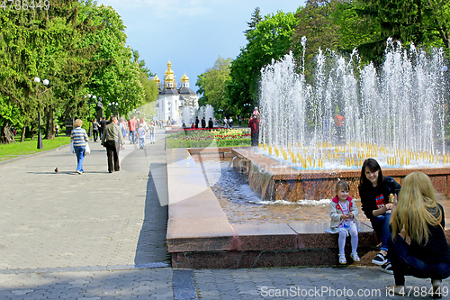 Image of People have a rest in city park with fountains