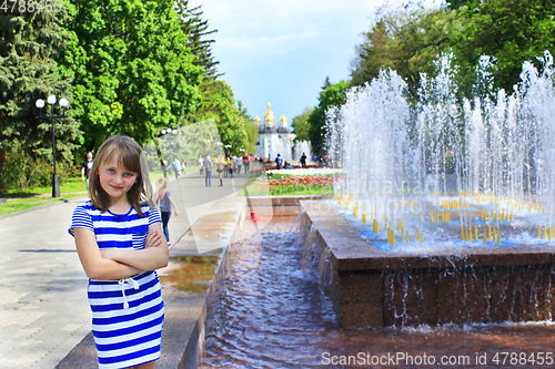 Image of modern young girl has a rest in the city park with fountains