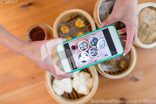 Image of Top view of cellphone taking photo on dim sum