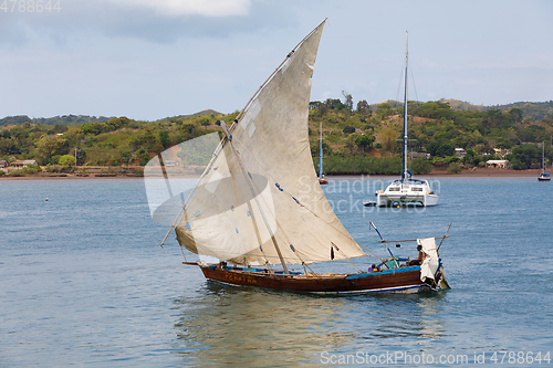 Image of Malagasy man on sea in traditional handmade dugout wooden sailin