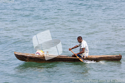 Image of Malagasy man on sea in traditional handmade dugout wooden boat
