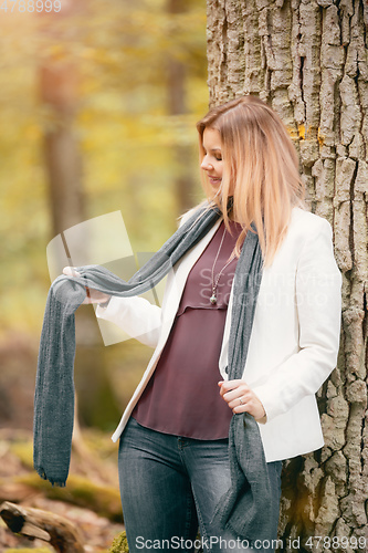 Image of young woman standing in the fall forest