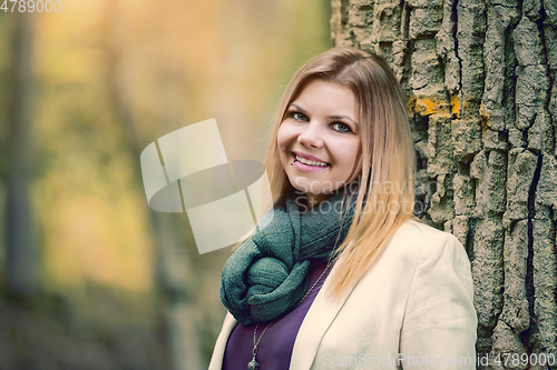 Image of young woman standing in the fall forest