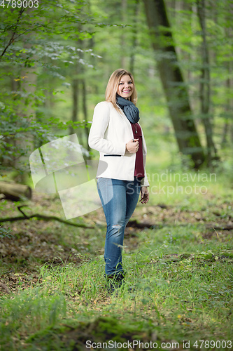 Image of young woman standing in the green forest