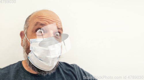 Image of astonished bald man with a mask