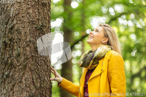 Image of young woman standing at the tree