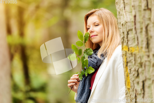 Image of young woman standing in the green forest