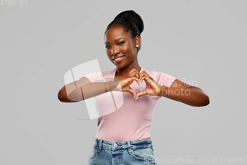Image of african american woman making hand heart gesture