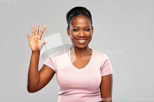 Image of happy african american woman showing five fingers