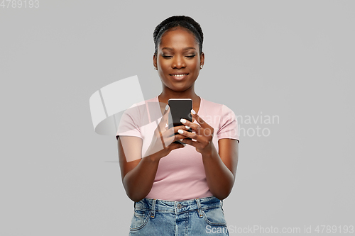 Image of happy african american woman using smartphone