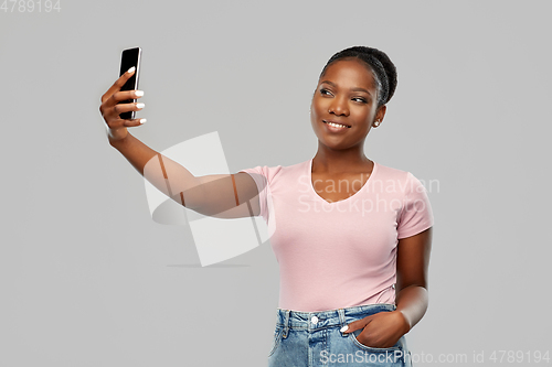 Image of african american woman taking selfie by smartphone