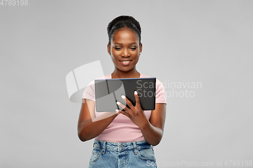 Image of happy african american woman using tablet pc