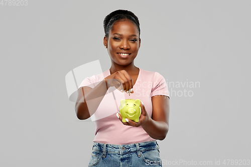 Image of happy african american woman with piggy bank