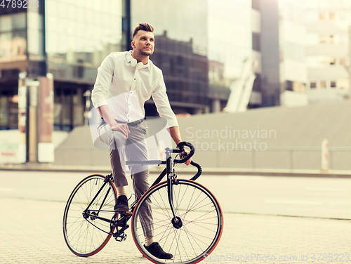 Image of man with bicycle and headphones on city street