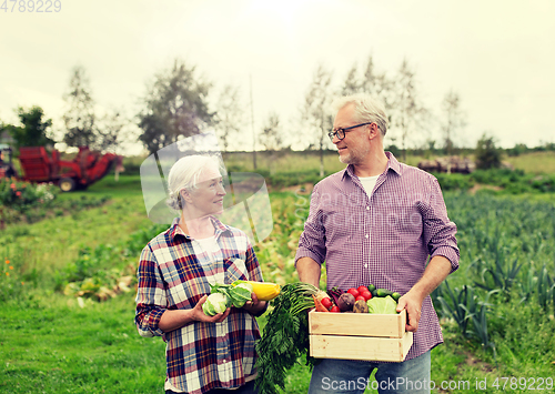 Image of senior couple with box of vegetables on farm