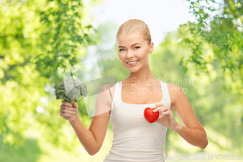 Image of happy smiling young woman with heart and broccoli