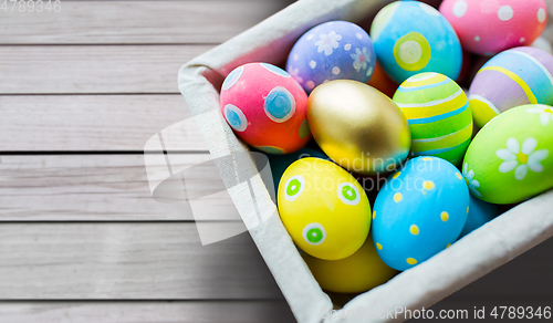 Image of close up of colored easter eggs in basket