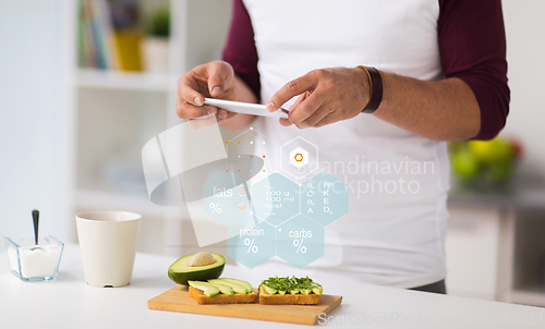 Image of hands with phone and food nutritional value chart