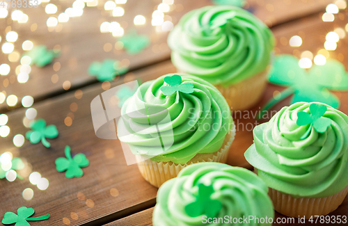 Image of green cupcakes and shamrock on wooden table