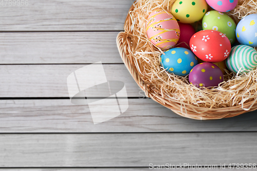 Image of close up of colored easter eggs in basket