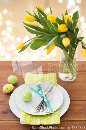 Image of easter egg, plates, cutlery and tulip flowers